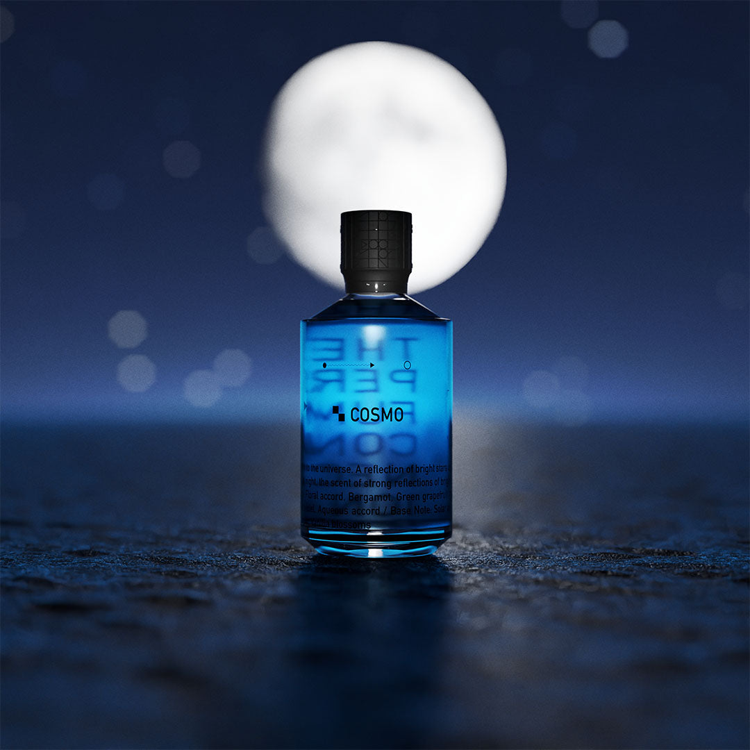 Parfumflesje "Cosmo" van The Perfume Connection met blauwe vloeistof, in een maanlichtscène tegen een nachtelijke hemel.